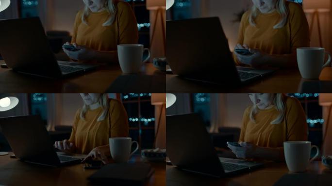 DS女人晚上在笔记本电脑上工作时检查她的智能手机