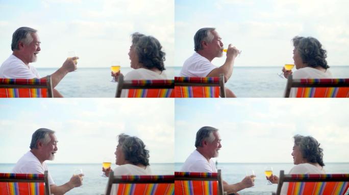 亚洲老年夫妇夏天在海滩度假时喜欢喝酒