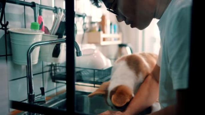 男人早上和他可爱的小狗在厨房里工作。