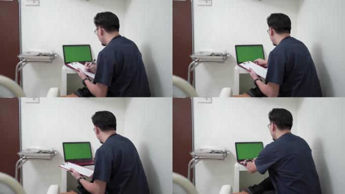 亚洲中国中年男性医生在笔记本电脑上查看患者记录