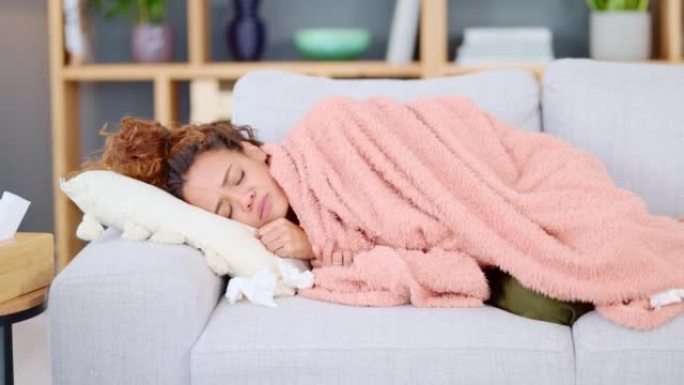生病的女人独自在家躺在沙发上感冒或流感。黑人女性咳嗽，看上去焦躁不安，躺在客厅的沙发上试图入睡。从c