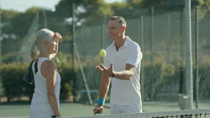 两名网球运动员站在一起在网球场上交谈