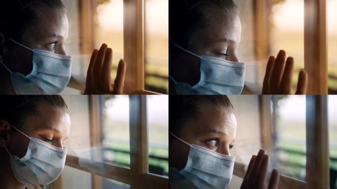 戴着面具的SLO MO女人透过窗户看，回想起新型冠状病毒肺炎禁闭期间的自由