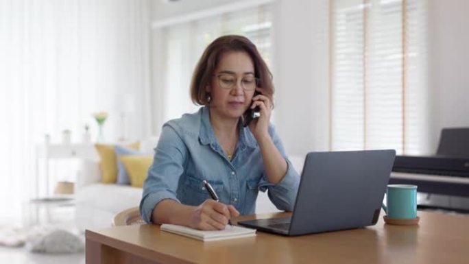 亚洲成熟女性在电话里谈心，在家认真讨论压力。