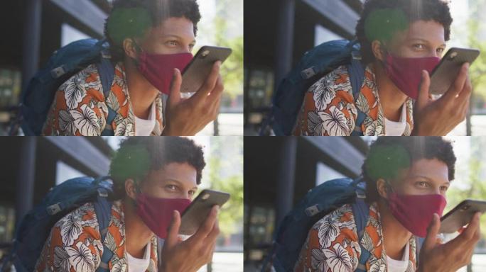 城市中的非裔美国人，戴着口罩坐在街上使用智能手机