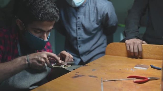 中东成人学生手工艺人在大学教室车间向他的讲师展示他的美术作品