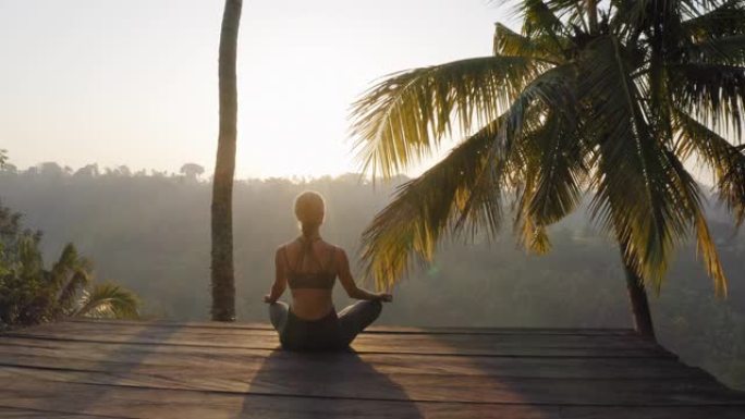 瑜伽女人在日出冥想练习正念冥想练习坐在户外甲板上在大自然4k