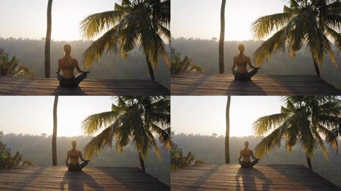 瑜伽女人在日出冥想练习正念冥想练习坐在户外甲板上在大自然4k
