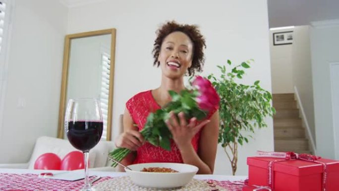 情人节约会视频通话中的快乐混血女人，手持鲜花