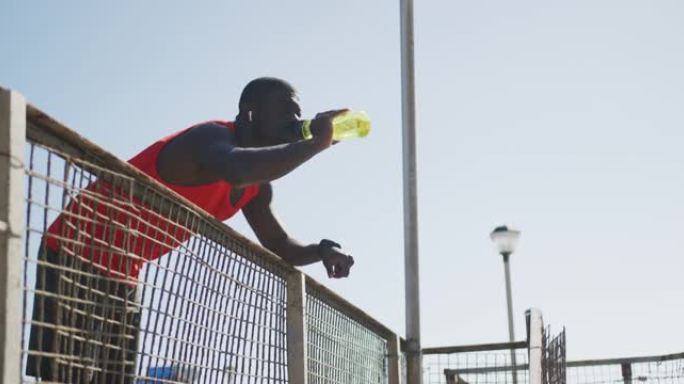 非裔美国人从水瓶中喝水并在户外锻炼休息