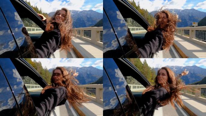 快乐的年轻女子玩得开心，在秋天的公路旅行中从车窗里倾斜
