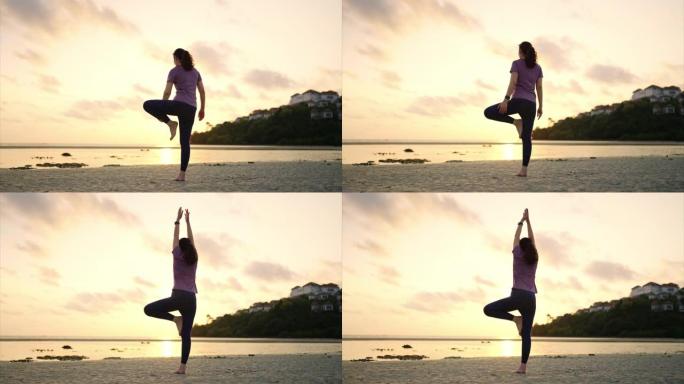 亚洲妇女在海滩上做瑜伽运动