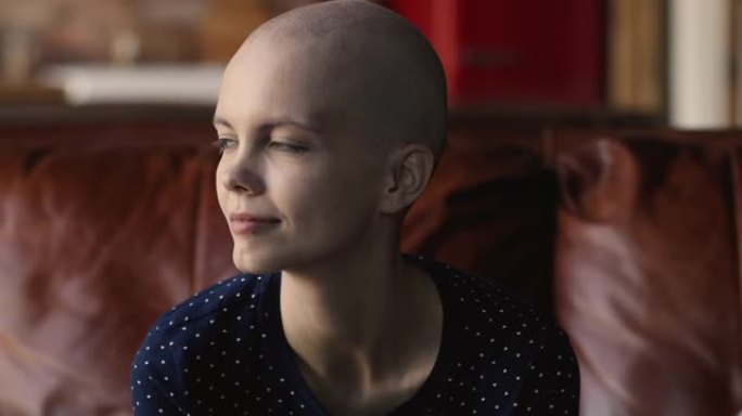 女性癌症患者坐在沙发上微笑看着远处