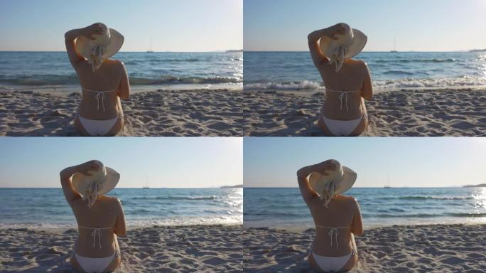 在海滩上戴着夏季帽的女人的慢动作视图。