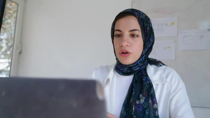 戴着头巾的穆斯林女商人在笔记本电脑上进行视频通话