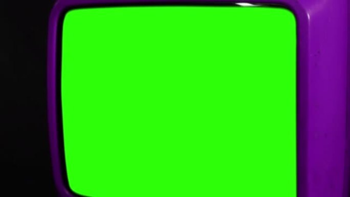 旧紫色电视打开带有静电噪音的绿色屏幕。特写。