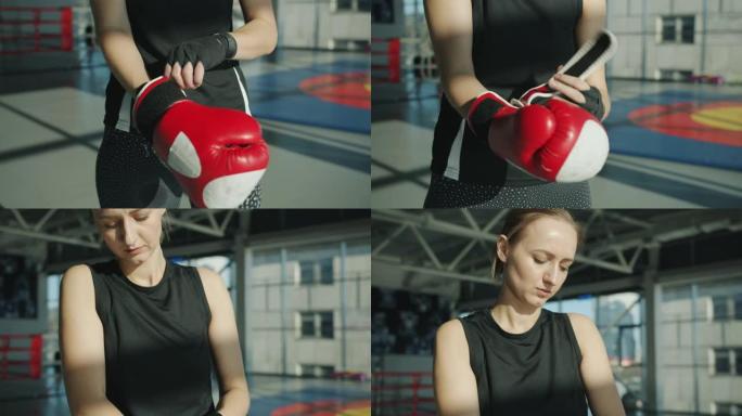 严肃的女拳击手戴上手套准备在现代体育馆进行拳击训练