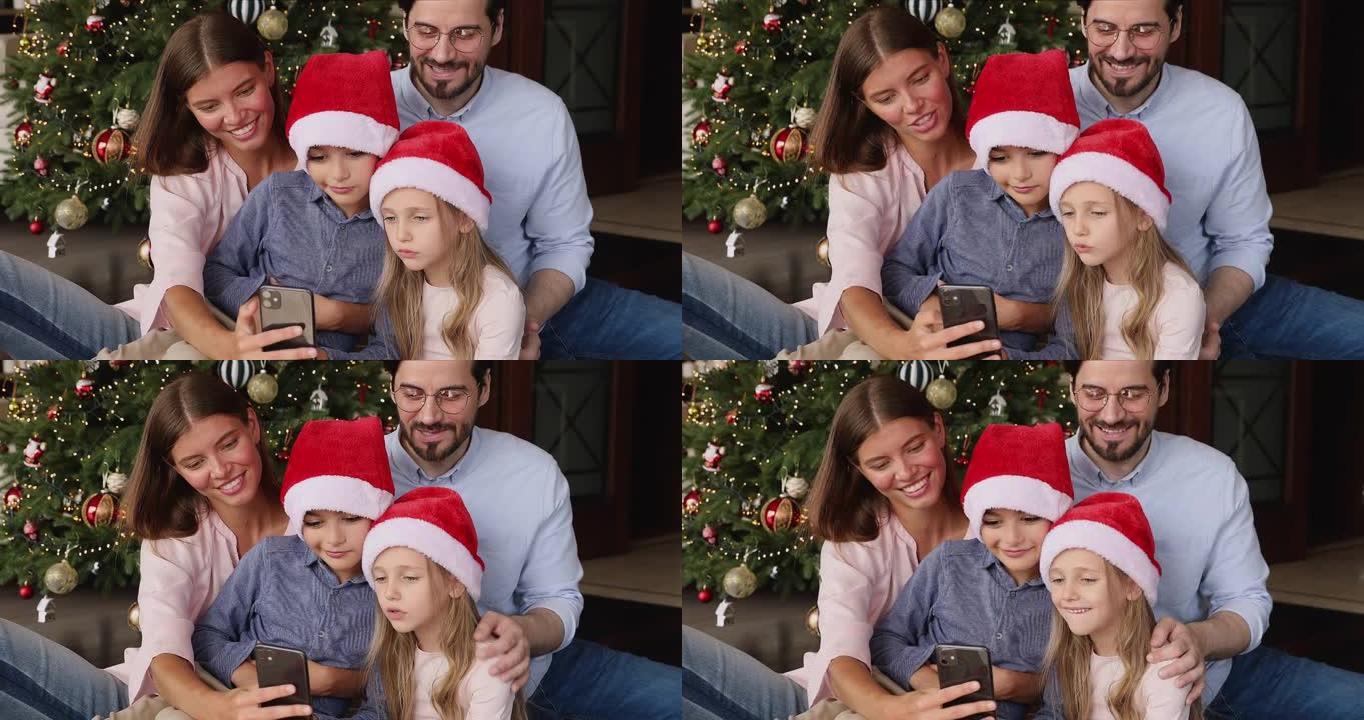 与青春期孩子的夫妇使用圣诞树上的手机应用程序