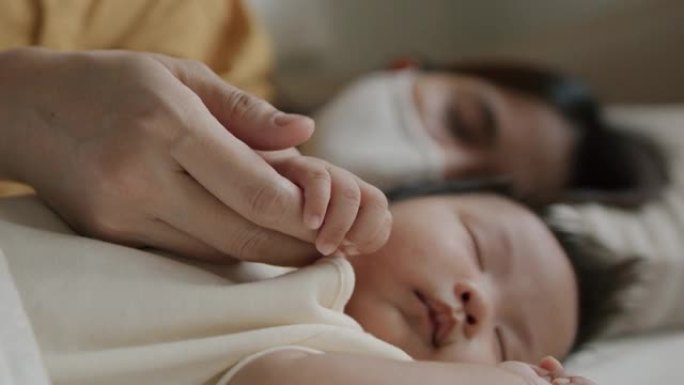 母亲和新生儿用防护面罩睡觉