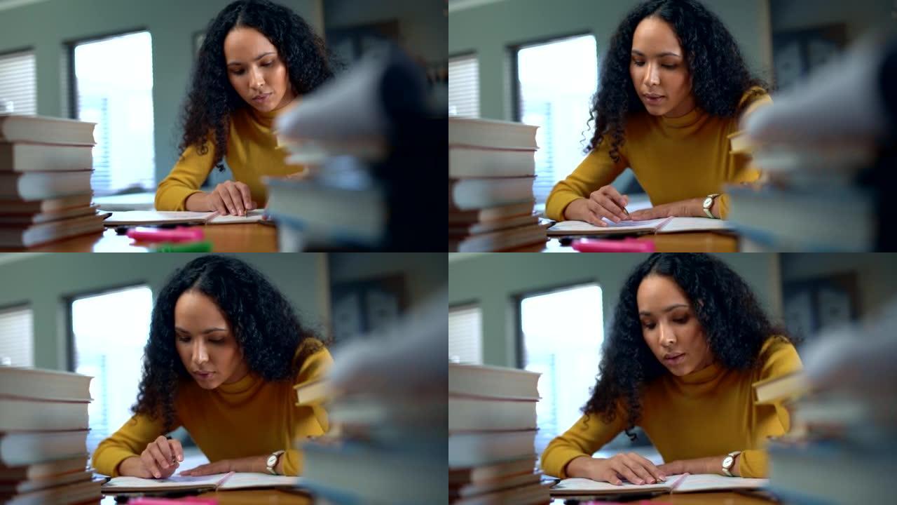 一名年轻的大学生在图书馆或家里的办公桌上学习期末考试时阅读笔记。妇女从学校或大学的教育教科书中准备学