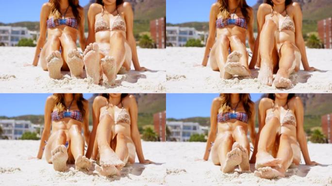4k视频片段，两名妇女在沙滩上扭动脚趾