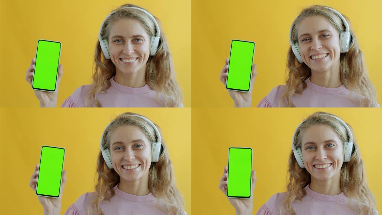 戴着绿屏色度键智能手机耳机的女孩肖像