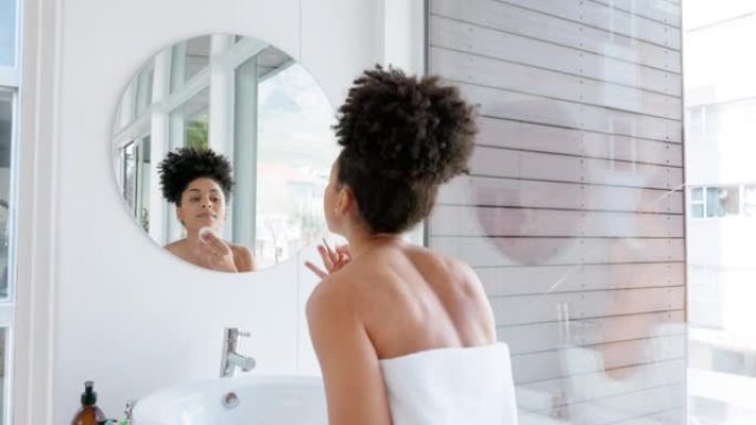 护肤，浴室美容和镜子中的女人，用于早晨护肤面部护理。健康，健康和黑人妇女在毛巾清洁面部，豪华排毒产品