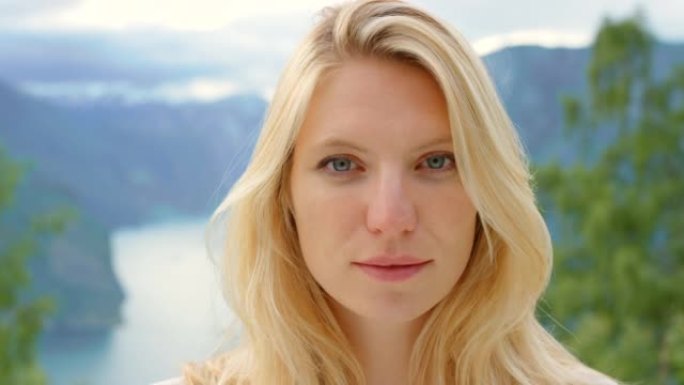 4k视频片段，一位迷人的年轻女子在m ø reog Romsdal远足时独自站立