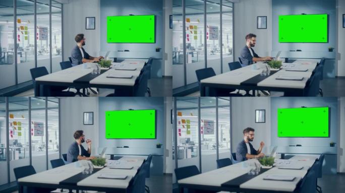 办公室会议室: 在笔记本电脑上工作的英俊的西班牙裔专家与绿屏Choma Key Wall电视互动。在