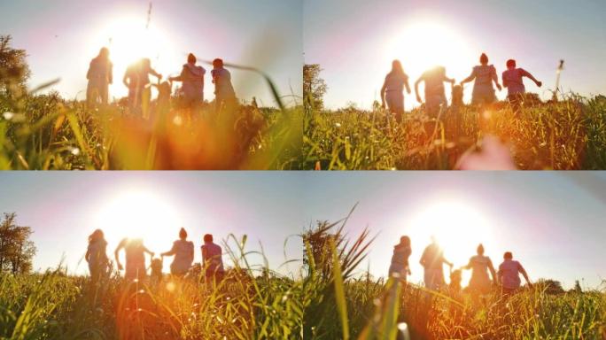 带着三个孩子的超级SLO MO家庭在日落时分在高草丛中奔跑