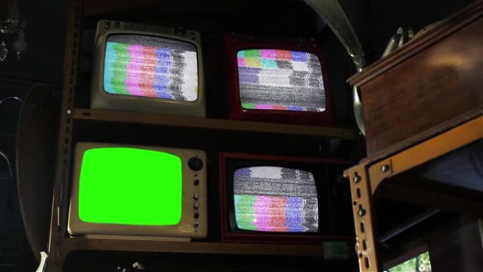 复古电视机打开绿屏，三台复古电视机打开古董店内的测试图案。