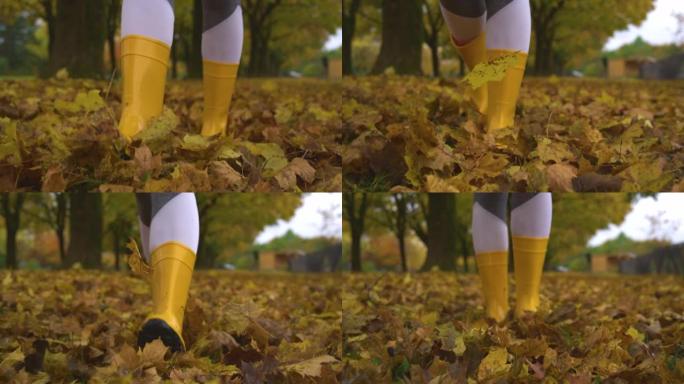 特写，DOF: 年轻的女性穿着靴子在秋天在公园里漫步。