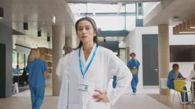 表情严肃的女医生肖像穿着白大褂站在繁忙的医院大楼里