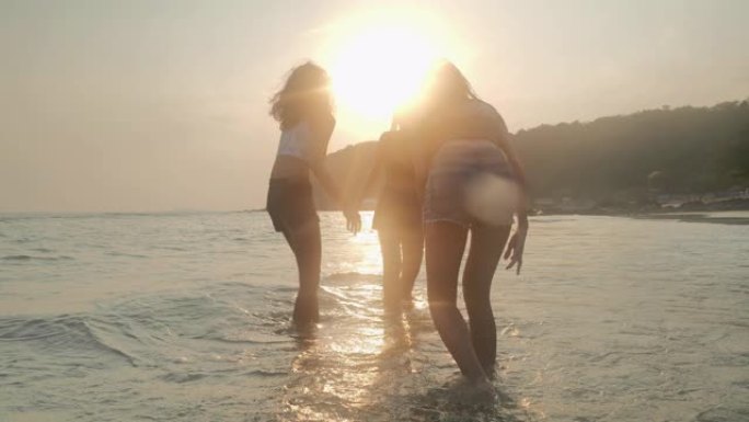 剪影三少女夏天在海滩上玩得开心。东南亚和东亚: 海滩上的乐趣