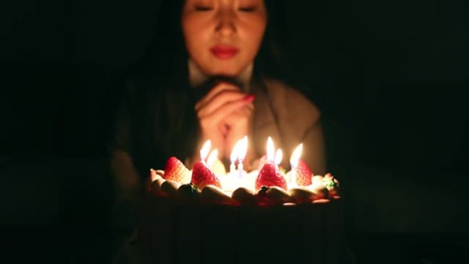 年轻女性在生日时用蛋糕祝福