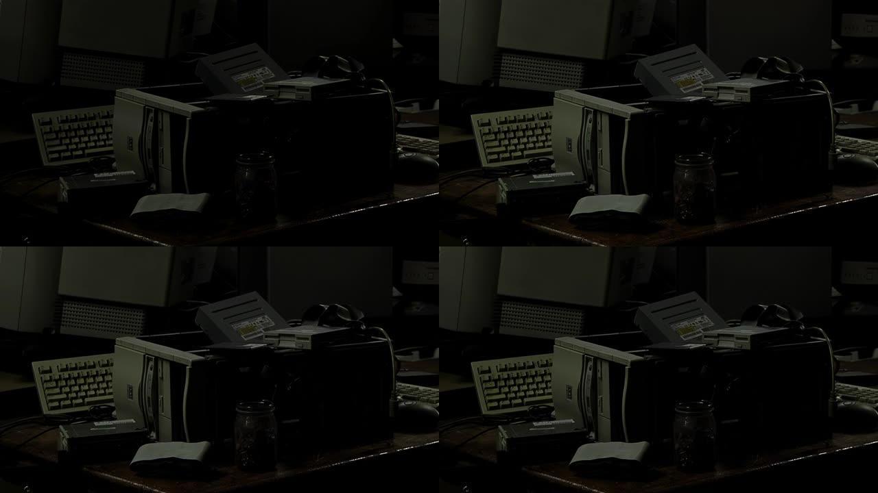 黑暗的房间里有许多坏掉的电脑和电子垃圾供处理。特写。