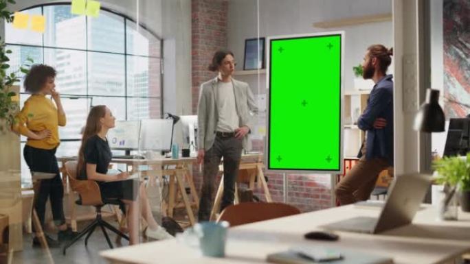 初级营销专家在创意办公室会议室进行团队演示。项目经理在绿屏模拟色度键显示上显示新的产品时间表。