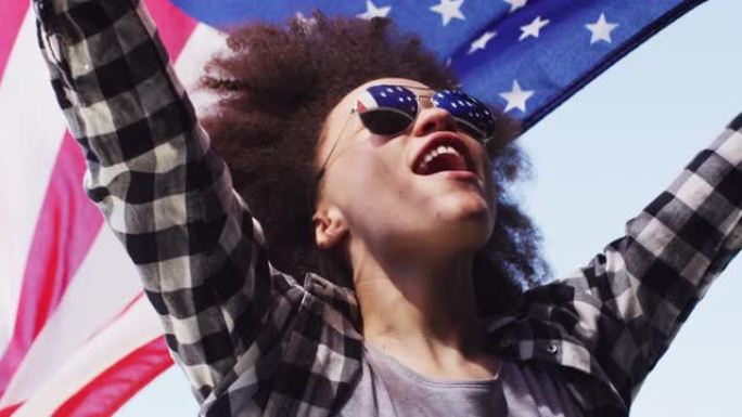 戴着墨镜的非洲裔美国妇女高举美国国旗