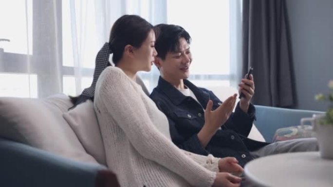 年轻夫妇一起用手机分享社交媒体