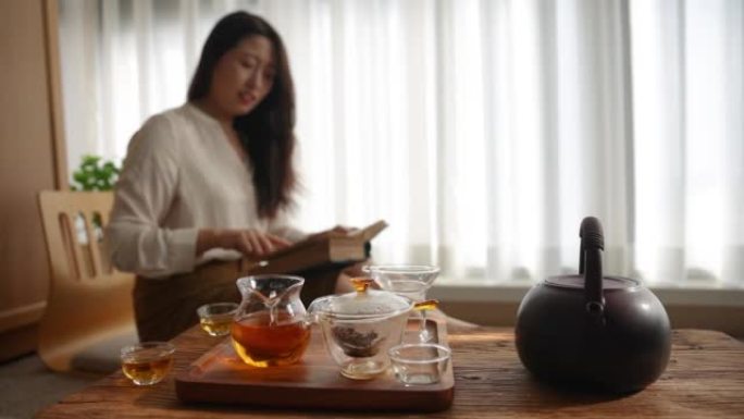 亚洲女子在家放松看书喝红茶
