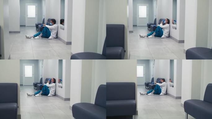 大流行期间，压力很大的中年医生在诊所走廊休息