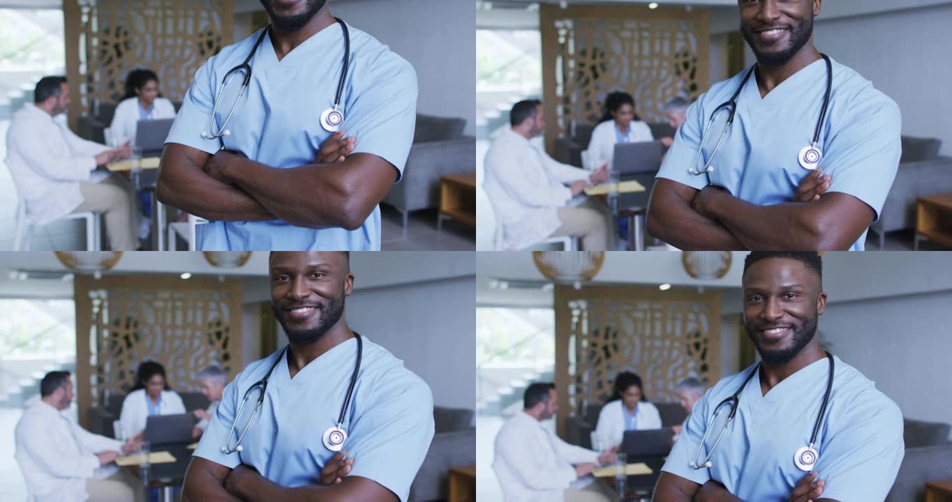 非洲裔美国男性医生微笑的肖像，背景中与同事讨论