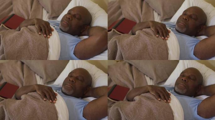 疲惫的非洲裔美国老人躺在床上睡着，床上看书