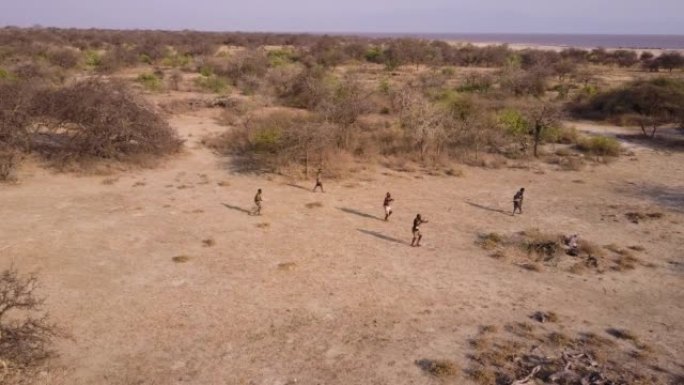 空中。由于气候变化，哈扎 (Hadza) 狩猎采集者部落成员在干旱的景观中用弓箭狩猎。坦桑尼亚