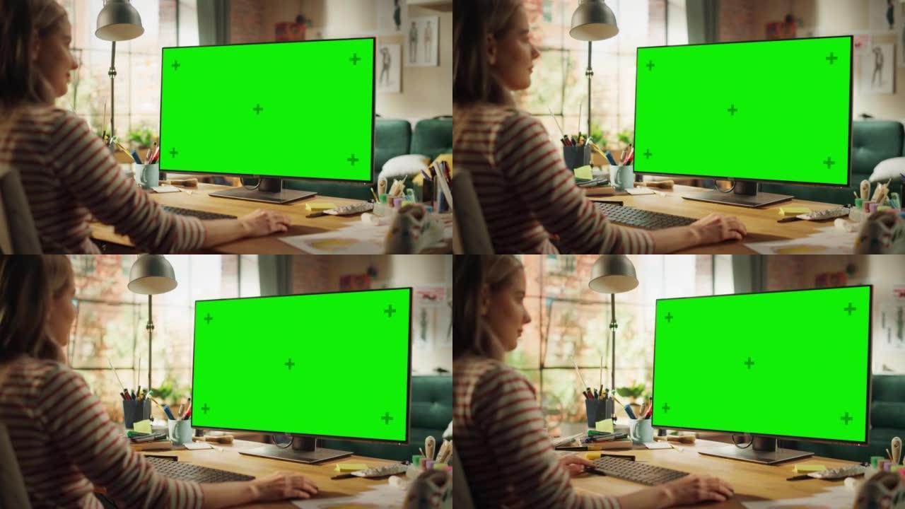 美丽的专业创意员工在她的个人计算机上工作，并带有绿色大屏幕模拟显示屏。她在凉爽的阁楼空间工作。学习和