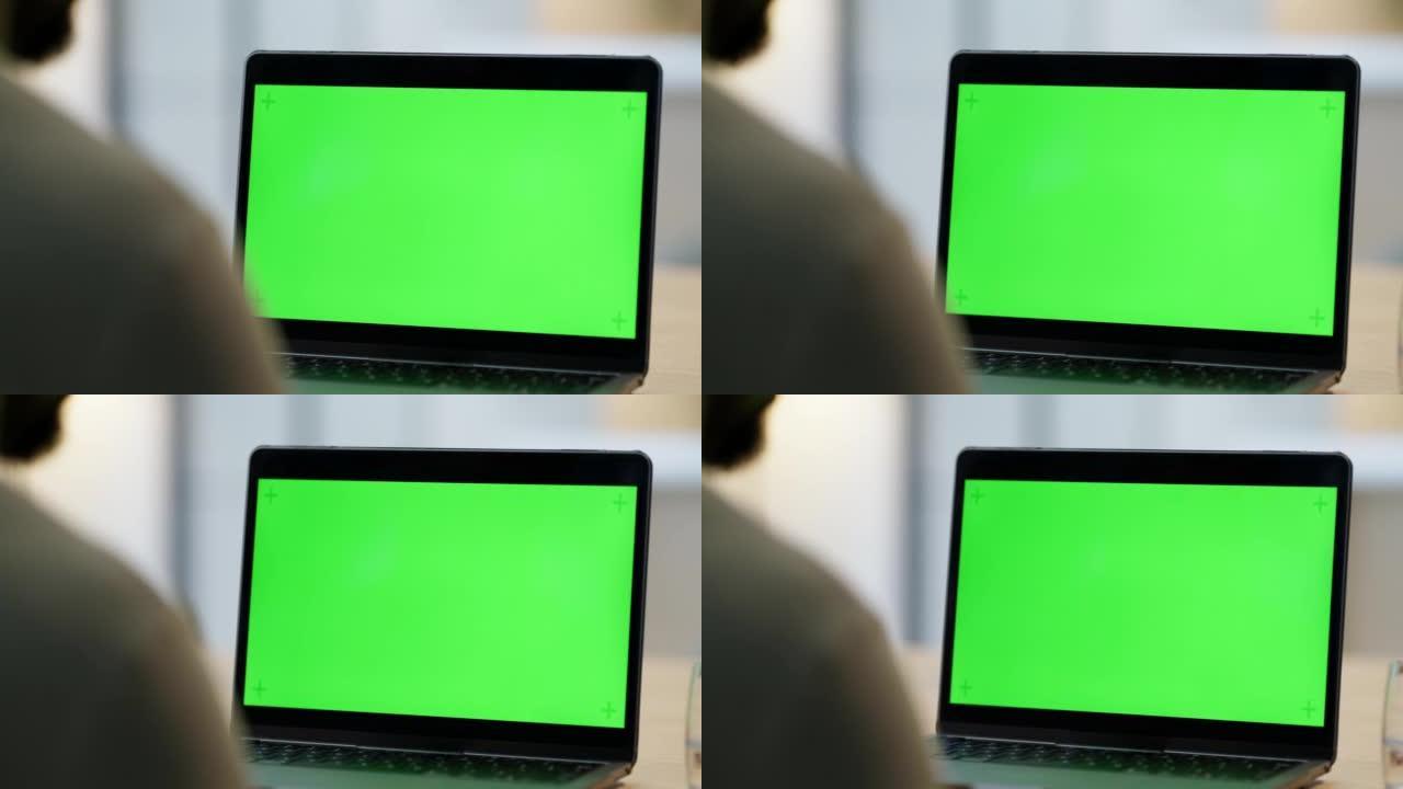 带有绿屏复制空间的笔记本电脑的特写镜头。一个不知名的商人在办公室使用技术。chromakey电脑显示