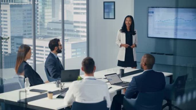 多元化办公室会议室会议: 亚洲女性项目经理为投资团队介绍数字业务扩展策略，使用带大数据分析的壁式电视