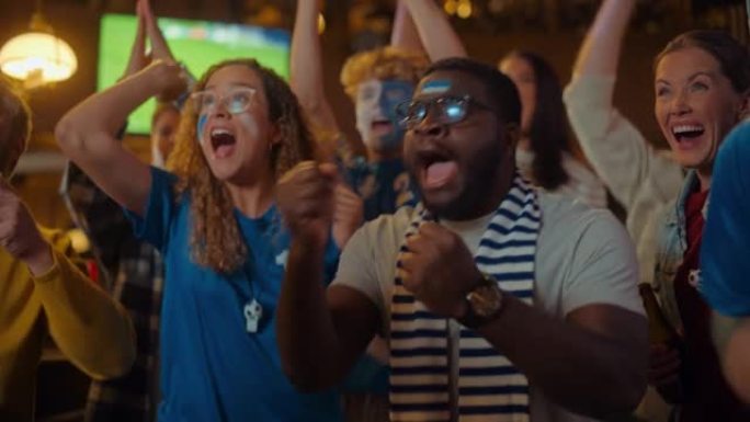 一群在体育酒吧直播足球比赛中，脸上涂着彩绘的球迷欢呼，尖叫，举手和跳跃。球员进球，朋友们庆祝。