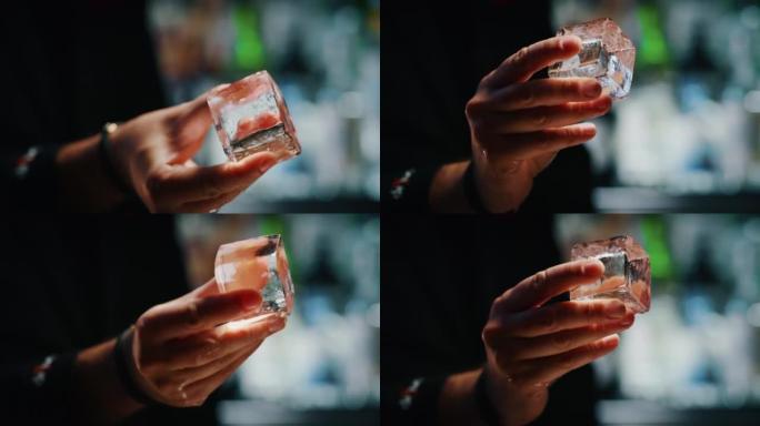 调酒师的特写镜头展示了一个专业的水晶持久冰块，用于与酒吧或迪斯科俱乐部的顾客一起准备酒精鸡尾酒。