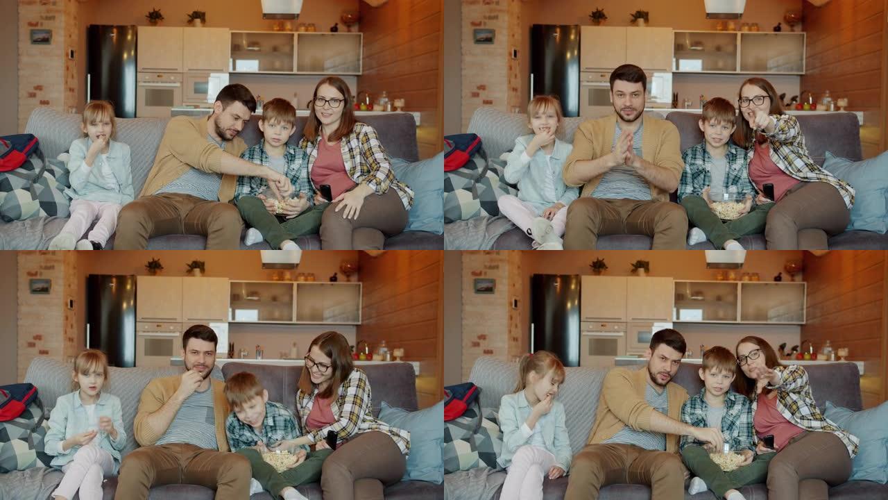 快乐家庭写真孕妇男孩女孩在家看电视吃爆米花